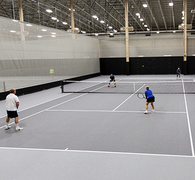 People playing tennis in the fieldhouse at SentryWorld