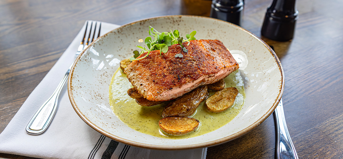 Salmon with lemon-dill cream, fingerling potato, roasted shallot, and wilted spinach.