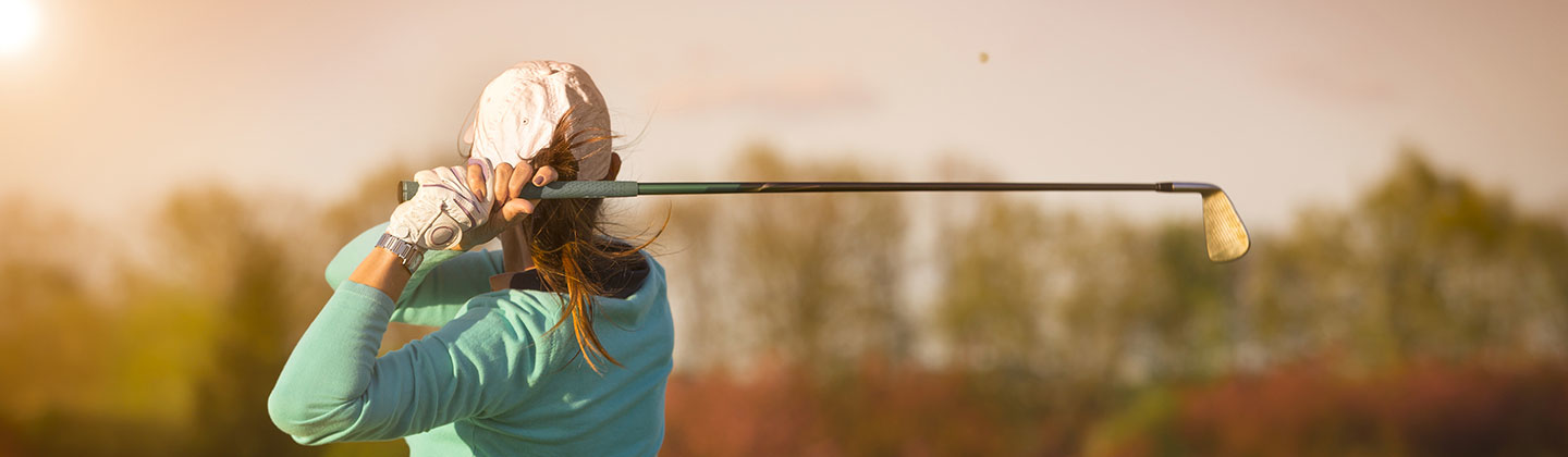 Woman swinging a golf club