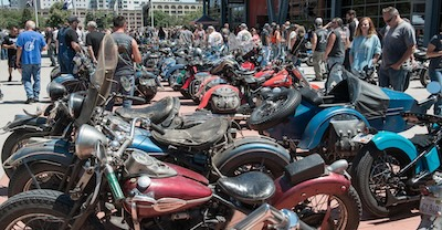 Parked motorcycles with a crowd of people