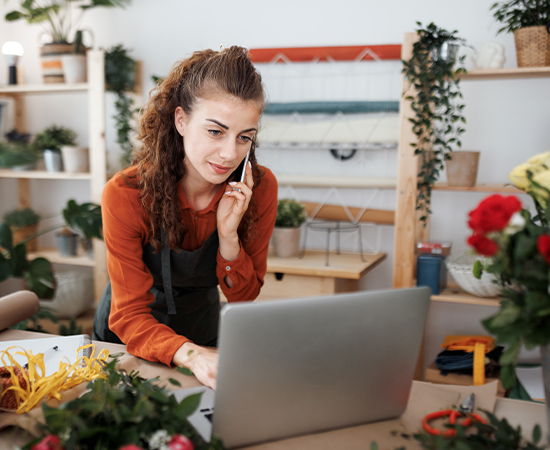 Florist talking with a customer and looking at a computer