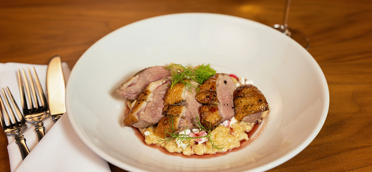 Seared duck breast with goat cheese risotto, fennel, and cranberry gastrique. 