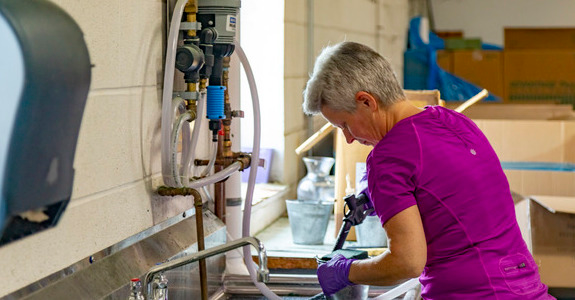 Baisch Skinner employee handing pesticides by a sink