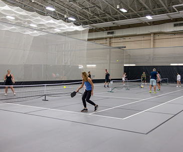 People playing pickleball in the fieldhouse at SentryWorld