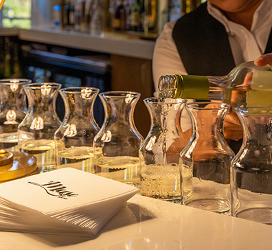 Server pouring wine into small containers on the Muse bar