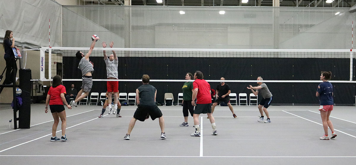 People playing volleyball on the courts in the SentryWorld fieldhouse