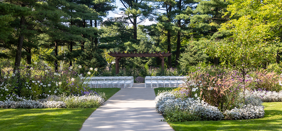 carousel-wedding-venue-pergola-1-1200x556 Pergola set up with white chairs for a wedding.