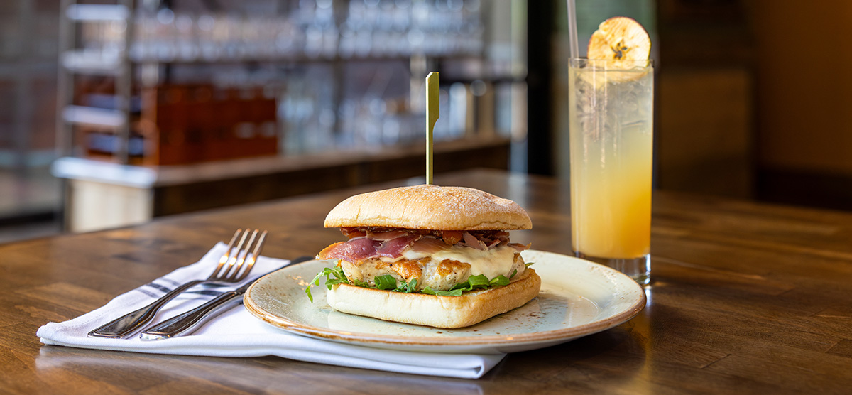 Grilled chicken sandwich with shaved prosciutto, peach jam, arugula, and fresh mozzarella on a cracked-wheat ciabatta.