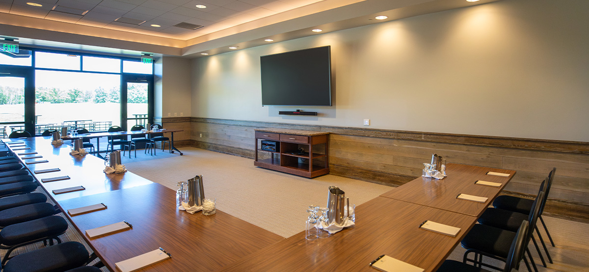 Meeting table, TV,  and wall of windows in the Community Room at SentryWorld