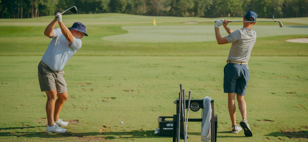 Two golfers on the practice area. 