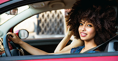 Young female driver behind the wheel of her car