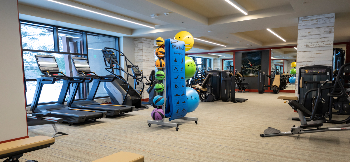 Gym equipment including treadmills, yoga mats, and weights.
