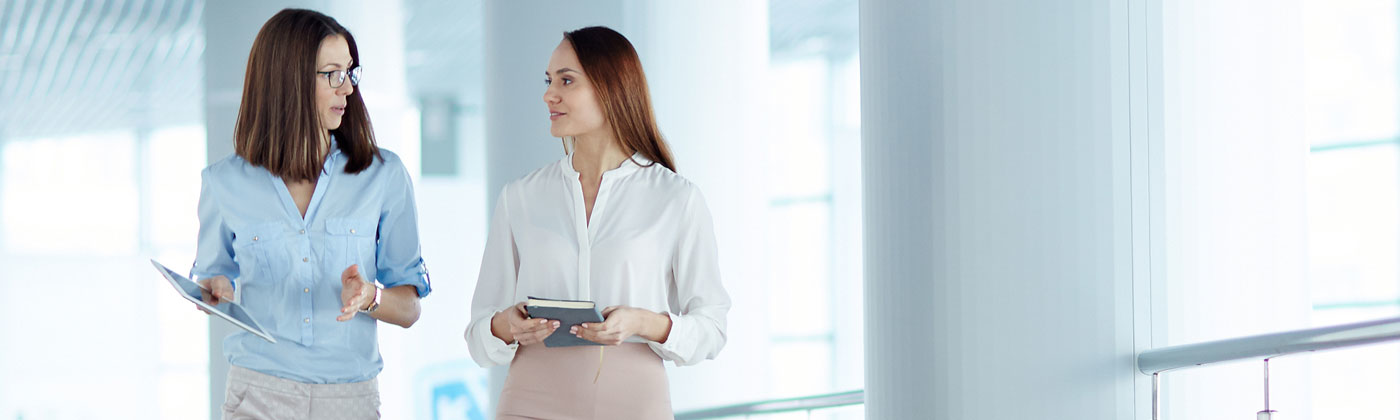 Two business women walking and talking