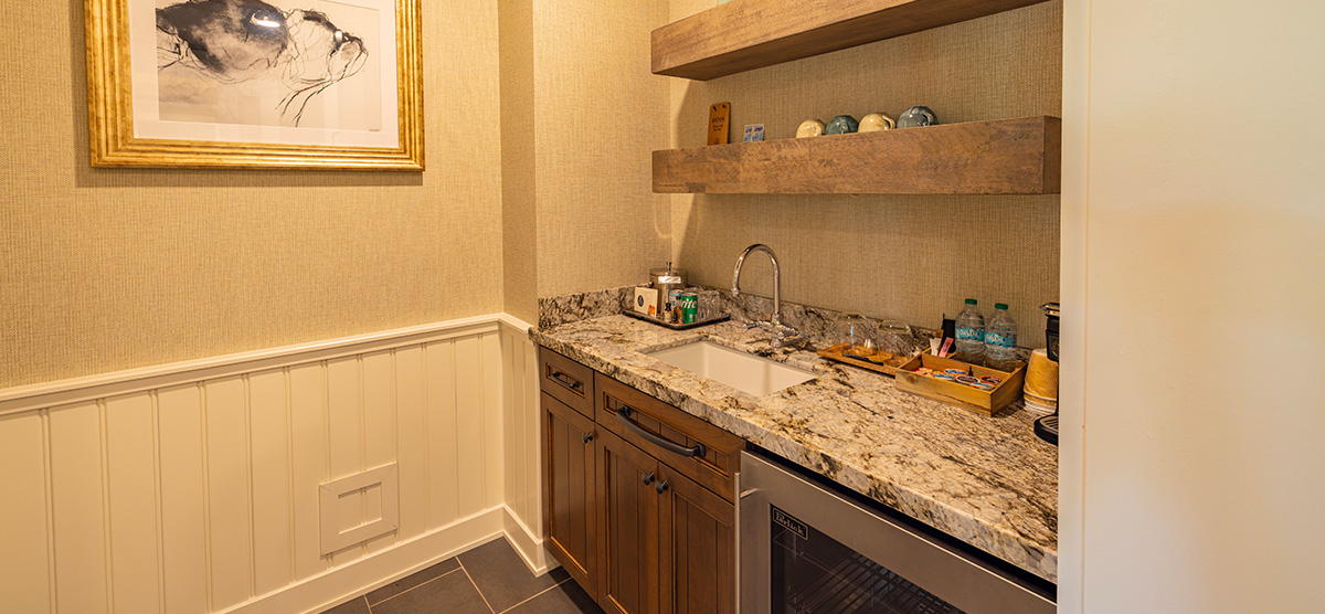 carousel-executive-king-suite-2br-6-1200x556 Wet bar counter, sink, and mini fridge.