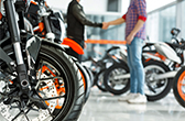 Two people shaking hands in a motorcycle dealership
