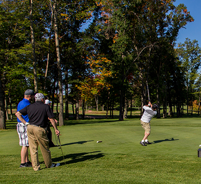 People teeing off at a SentryWorld tee box