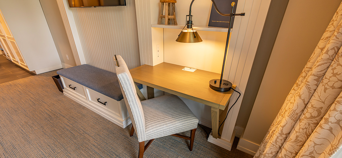 carousel-accessible-queen-terrace-3-1200x556 Desk area with chair and lamp.