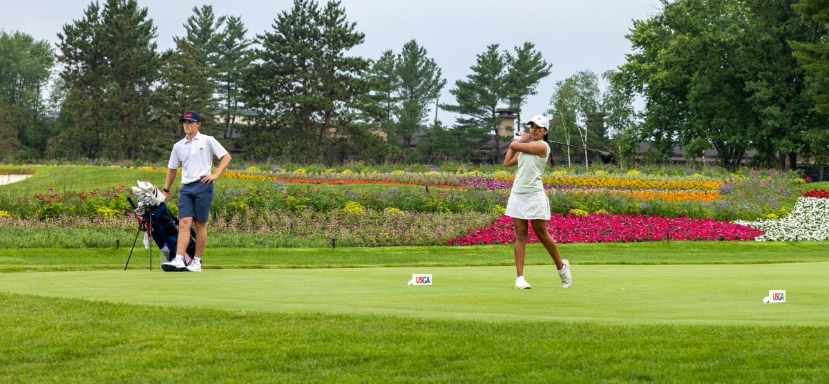 Golfer and caddie on a tee box at SentryWorld.