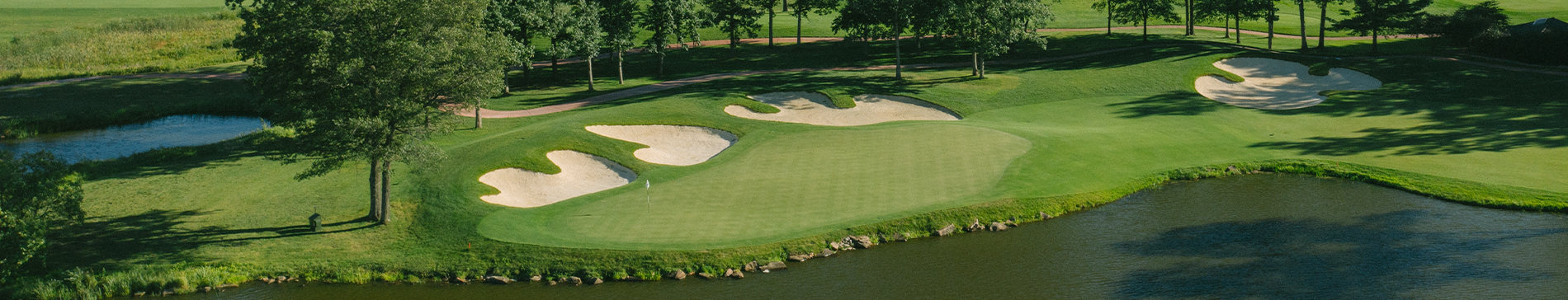 Aerial view of sand traps and a water hazard next to a putting green at SentryWorld