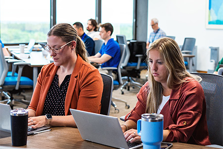 Two Sentry associates taking notes during a class at Sentry University