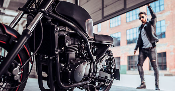 Parked motorcycle inside a garage and a man closing the garage door