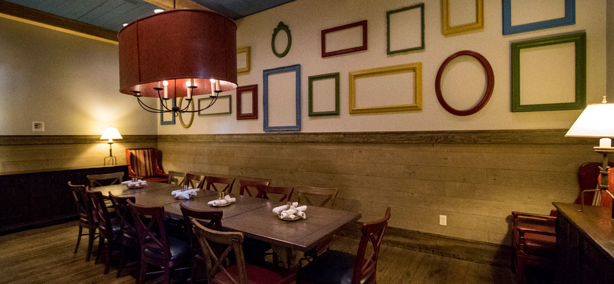 Colorful picture frames on the wall and a dining table in the Celebration Room