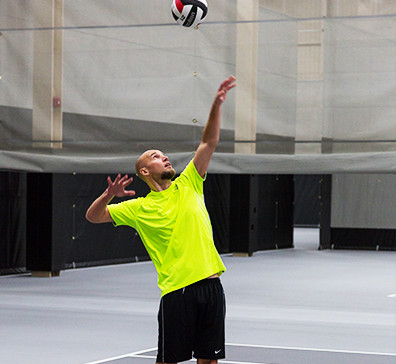 Player serving a volleyball in the fieldhouse at SentryWorld