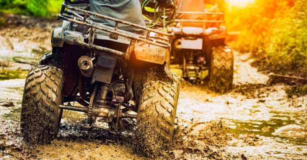 Two ATVs driving in mud