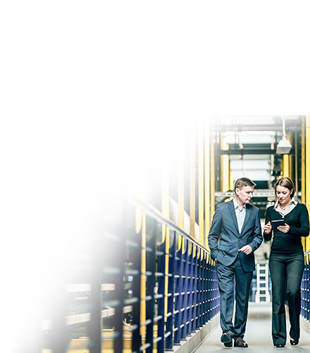 Two business professionals waking through an aisle in a warehouse