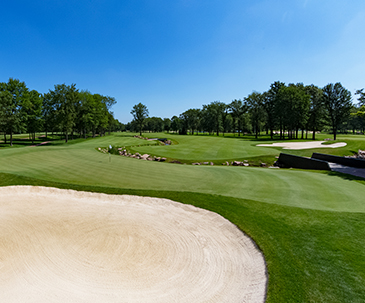 Sand trap and a small bridge next to a putting green on the SentryWorld golf course