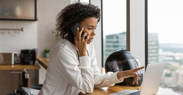 Woman talking on phone while using computer