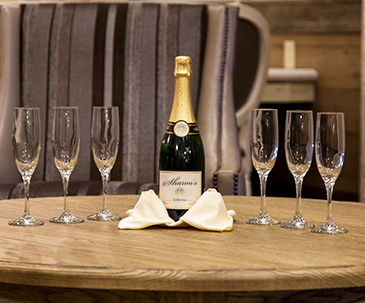 Champaign bottle and glasses lined up on a table