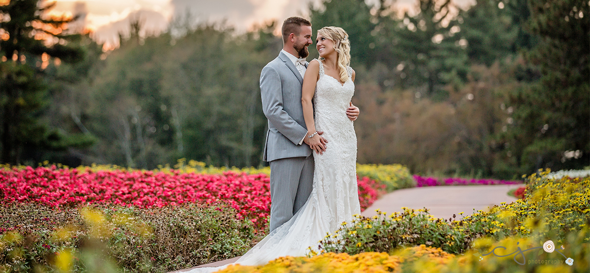 Bride and groom smiling at one another on the flower hole at the SentryWorld golf course