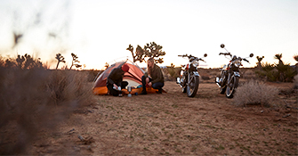 Two young women camping with motorcycles