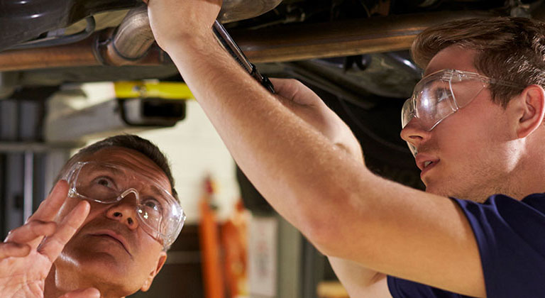 Two men working under a car