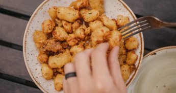 Person eating cheese curds from a plate. 