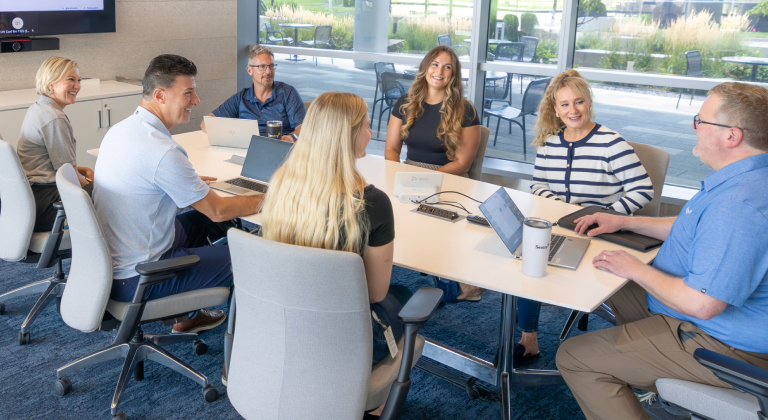 Group of associates working together at a conference table.