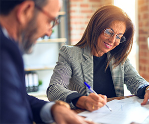 Two people looking at papers on a table.