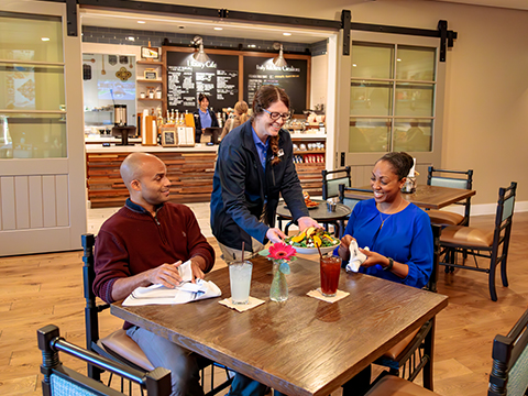 A waitress serving customers at the Library Cafe located within the Inn at SentryWorld.
