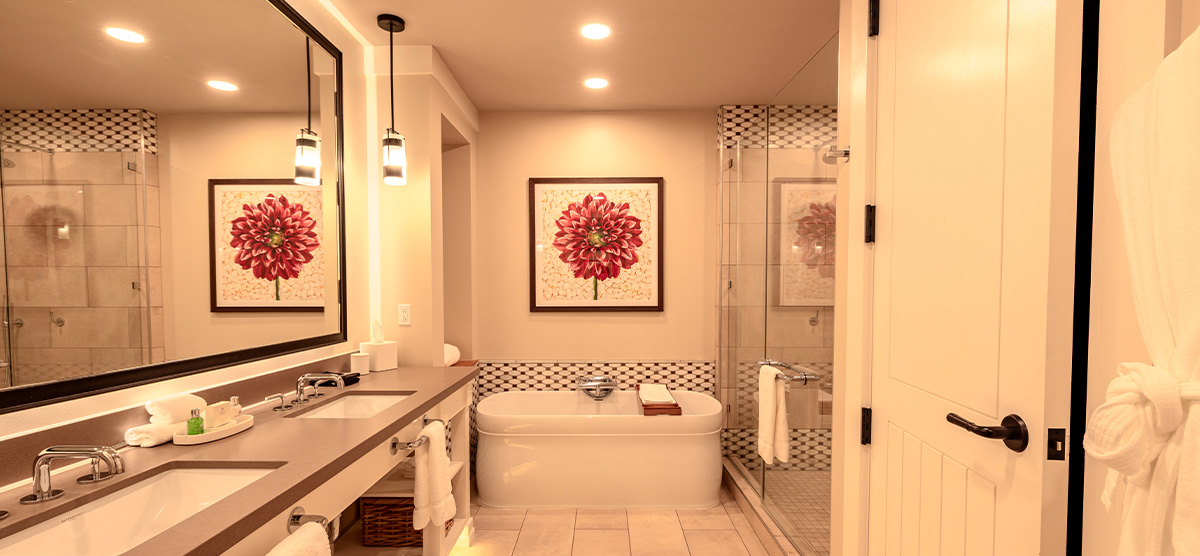 carousel-suite-golf-view-luxury-junior-6-1200x556 Bathroom with two sinks, tub, and glass shower area.