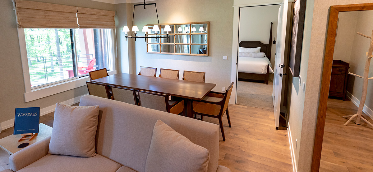 carousel-executive-king-suite-1br-3-1200x556 Executive suite parlor area with dining room table and seating area.