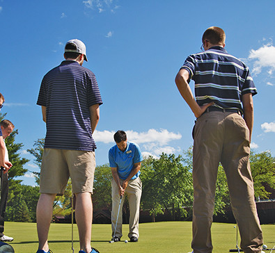 People putting on a green at the SentryWorld golf course