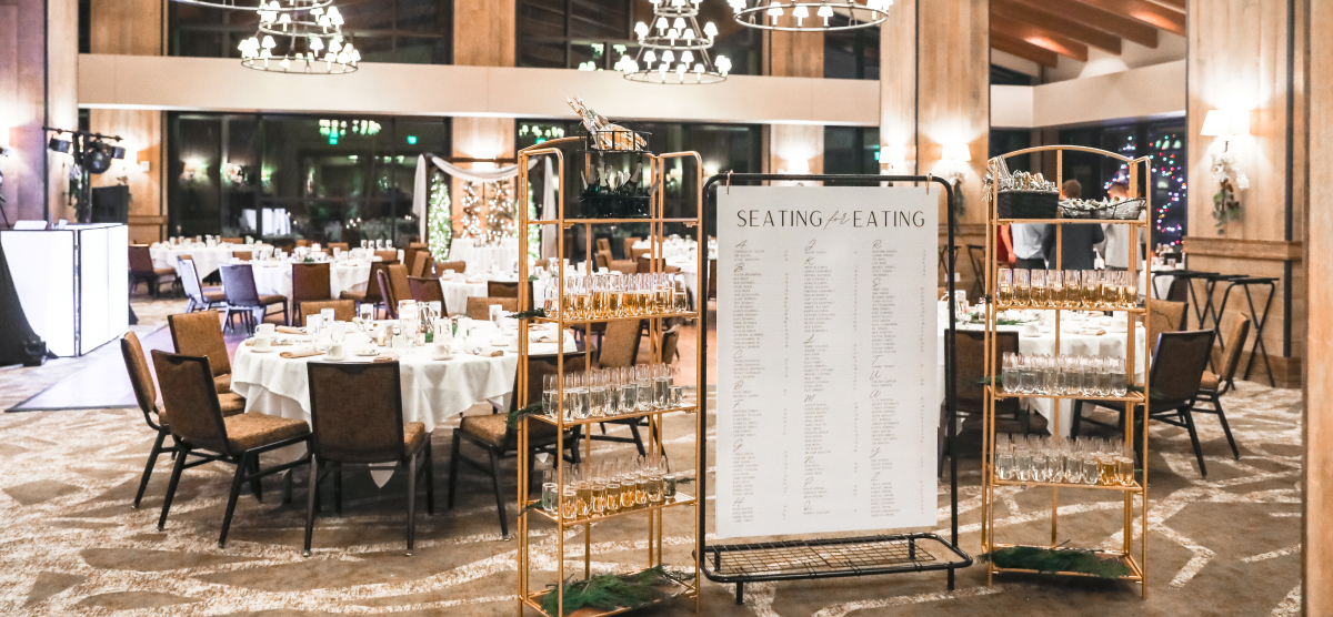 SentryWorld grand hall with set tables, a seating chart, and shelves of drinks for a reception.