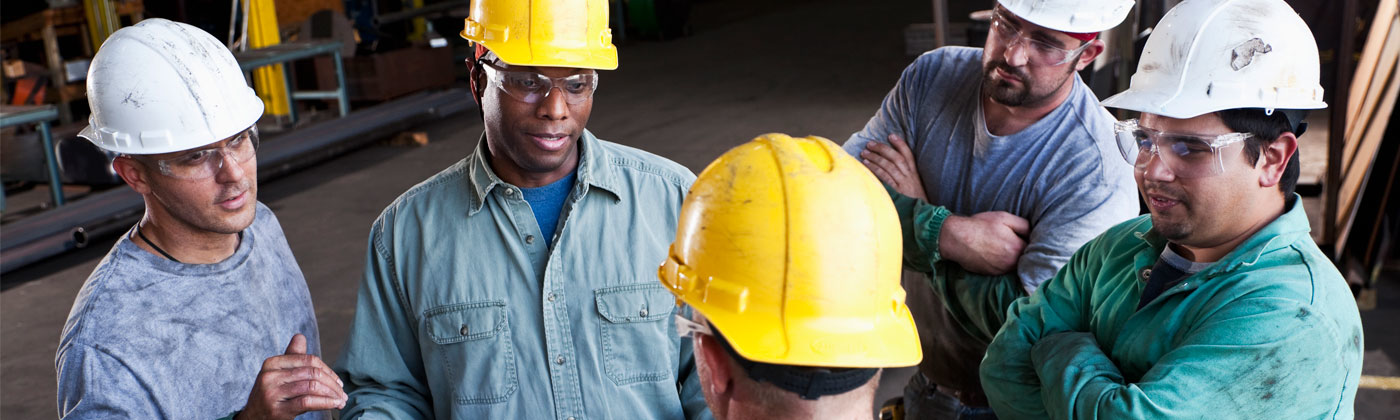 Group of men in hard hats in warehouse