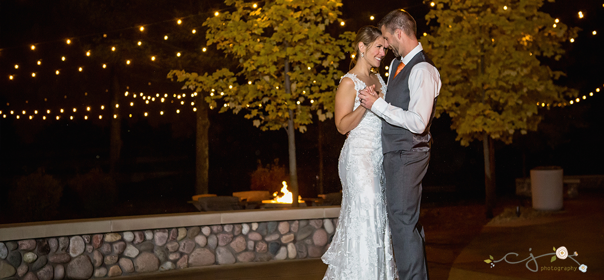 Bride and groom dancing outside by a fireplace at SentryWorld