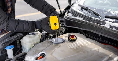 Man pouring oil into engine bay