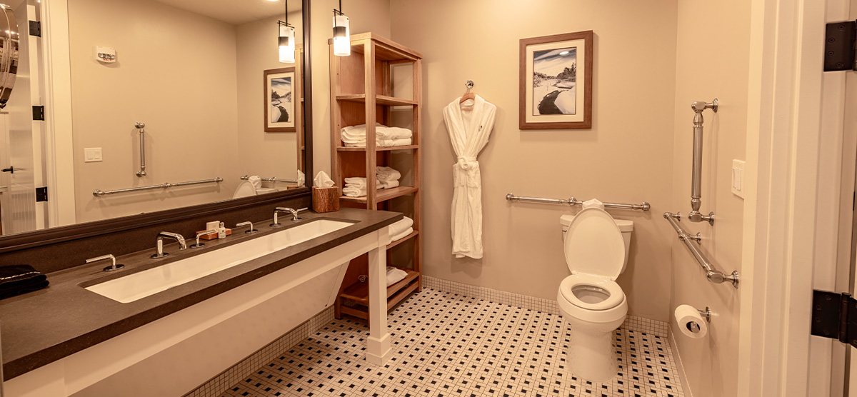 carousel-accessible-golf-view-king-suite-4-1200x556 Accessible bathroom with sink wheelchair space and grab bars.
