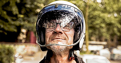 Smiling biker looking through visor of his motorcycle helmet