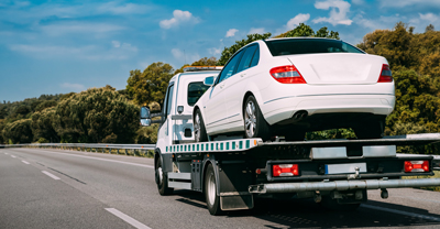 Flatbed tow truck with car