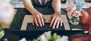 Closeup of someones hands typing on a keyboard